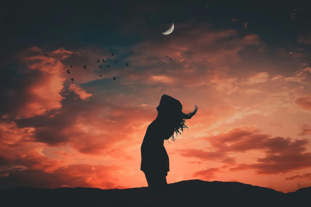 pexels-photo-1835016-1835016 A silhouetted person under a crescent moon at twilight, evoking tranquil and peaceful vibes.